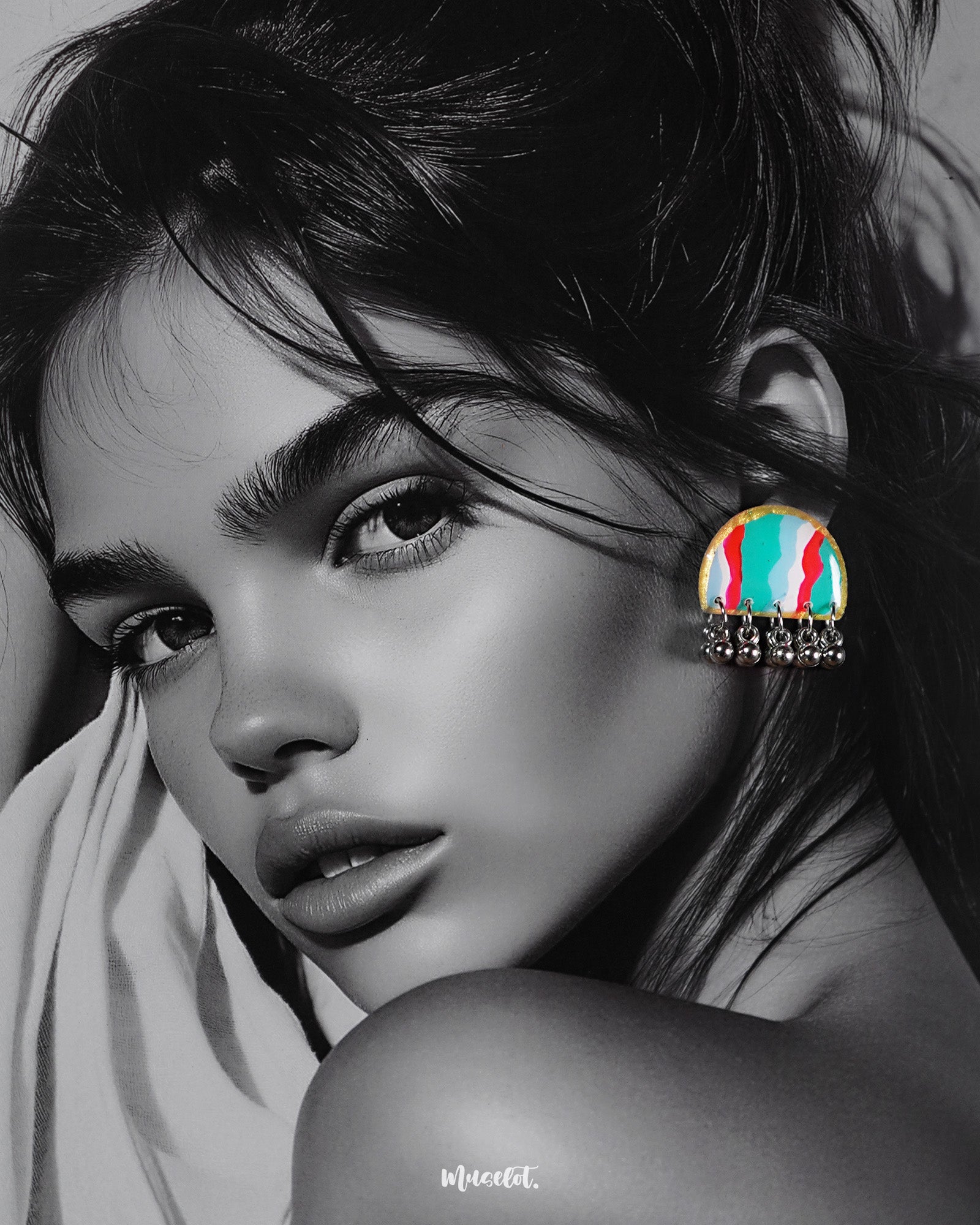 A woman wears the Aabshaar handmade stud earrings, their vibrant semi-circle design in green, red, white, and blue beautifully highlighted against her skin, while oxidized silver ghungroos dangle delicately below—capturing the essence of playful elegance — Muselot.