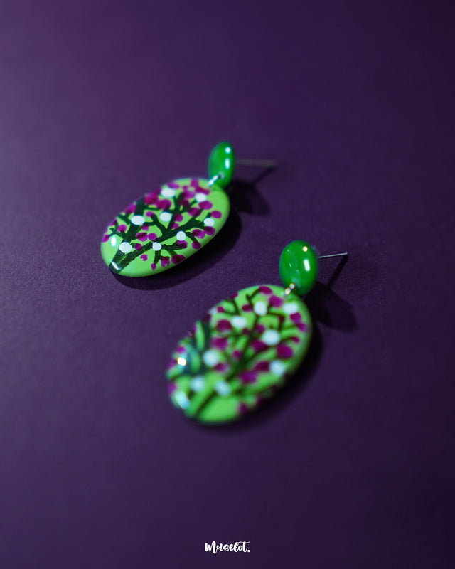 A close-up shot of Baaghani green floral drop earrings featuring soft handcrafted petals and subtle detailing, showcasing the artisanal touch and botanical elegance of the design — Muselot.