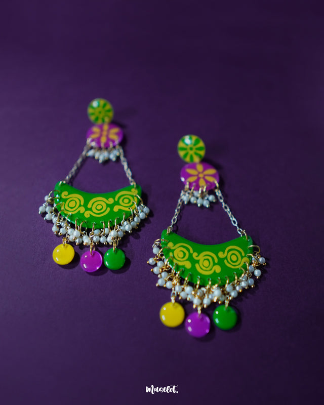 Baharaan green chandbali earrings placed against a purple background, highlighting their crescent shape, vibrant detailing, and handcrafted charm that showcases a blend of tradition and playfulness — Muselot.