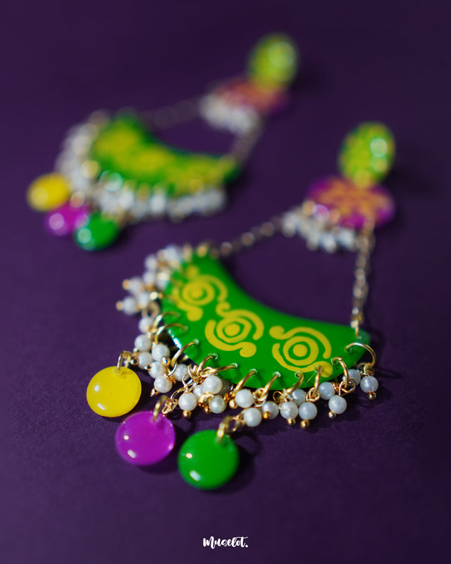 A close-up shot of Baharaan green chandbali earrings featuring intricate hand-painted patterns and tiny metallic beads, showcasing fine craftsmanship and highlighting their festive appeal — Muselot.