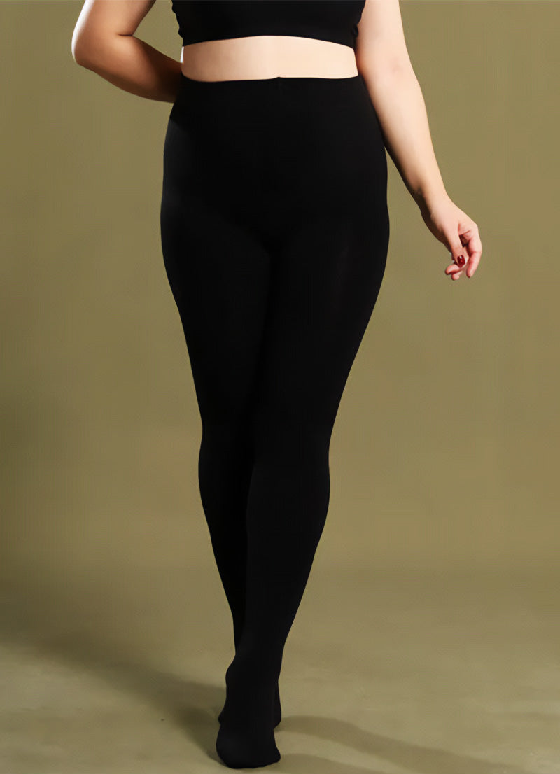 A plus-size woman in black thermal tights showcasing their smooth texture and snug, comfortable fit - Muselot