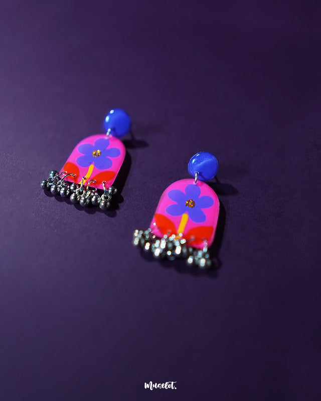 Benazir handmade floral drop earrings placed against a rich purple background, highlighting the vibrant petals and delicate handcrafted details that give the piece its artistic charm — Muselot