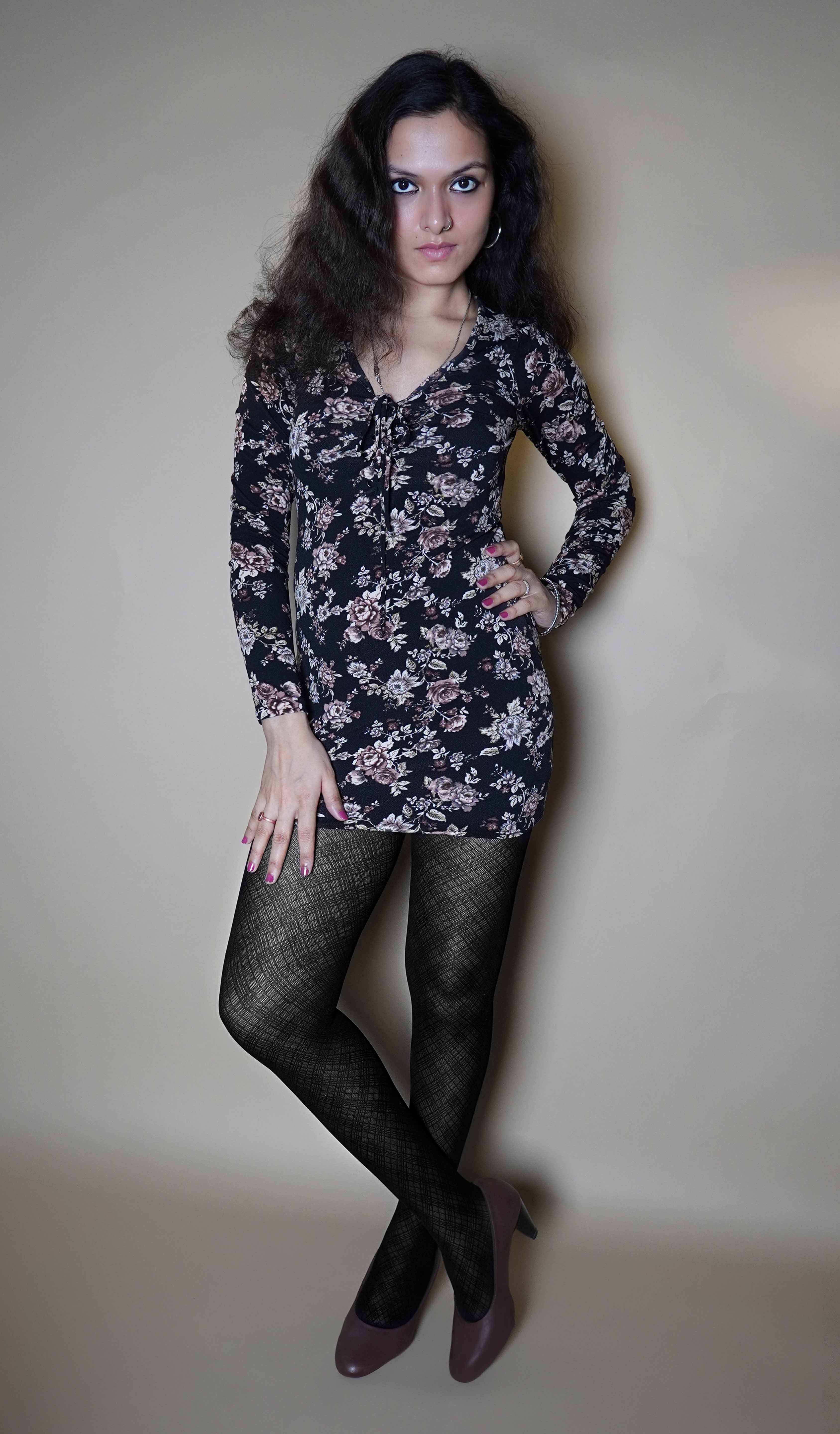 A woman wearing sheer stocking in pattern design for girls, posing with her hand on her waist and other on her thigh as she looks confidently at the camera, showcasing the voguish sexy look-Muselot