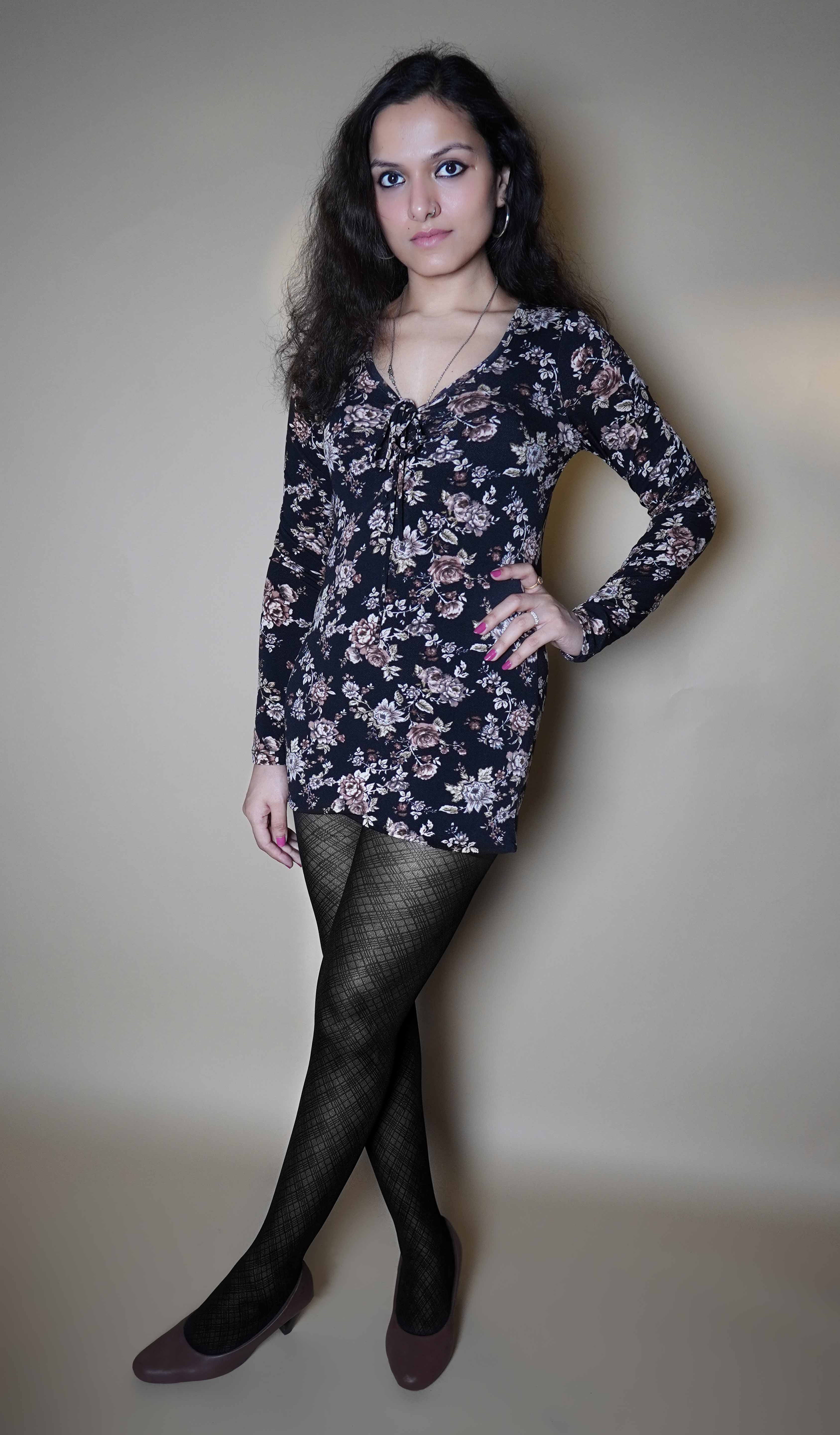 A woman wearing black patterned stretchable stocking, posing with her hand on her waist and other hanging on her side, showcasing the modish trendy look-Muselot