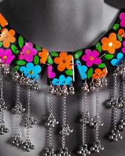 Close-up view of the black floral necklace set worn by a model, showcasing the intricate floral accents and beaded craftsmanship that gracefully trace the neckline, adding a refined touch to the overall ensemble — Muselot
