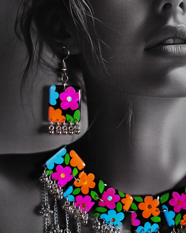 A close-up shot of a woman wearing the black floral necklace set, focusing on the delicate handcrafted flowers and beaded detailing resting gracefully along her neckline, enhancing the elegance of the overall look — Muselot.