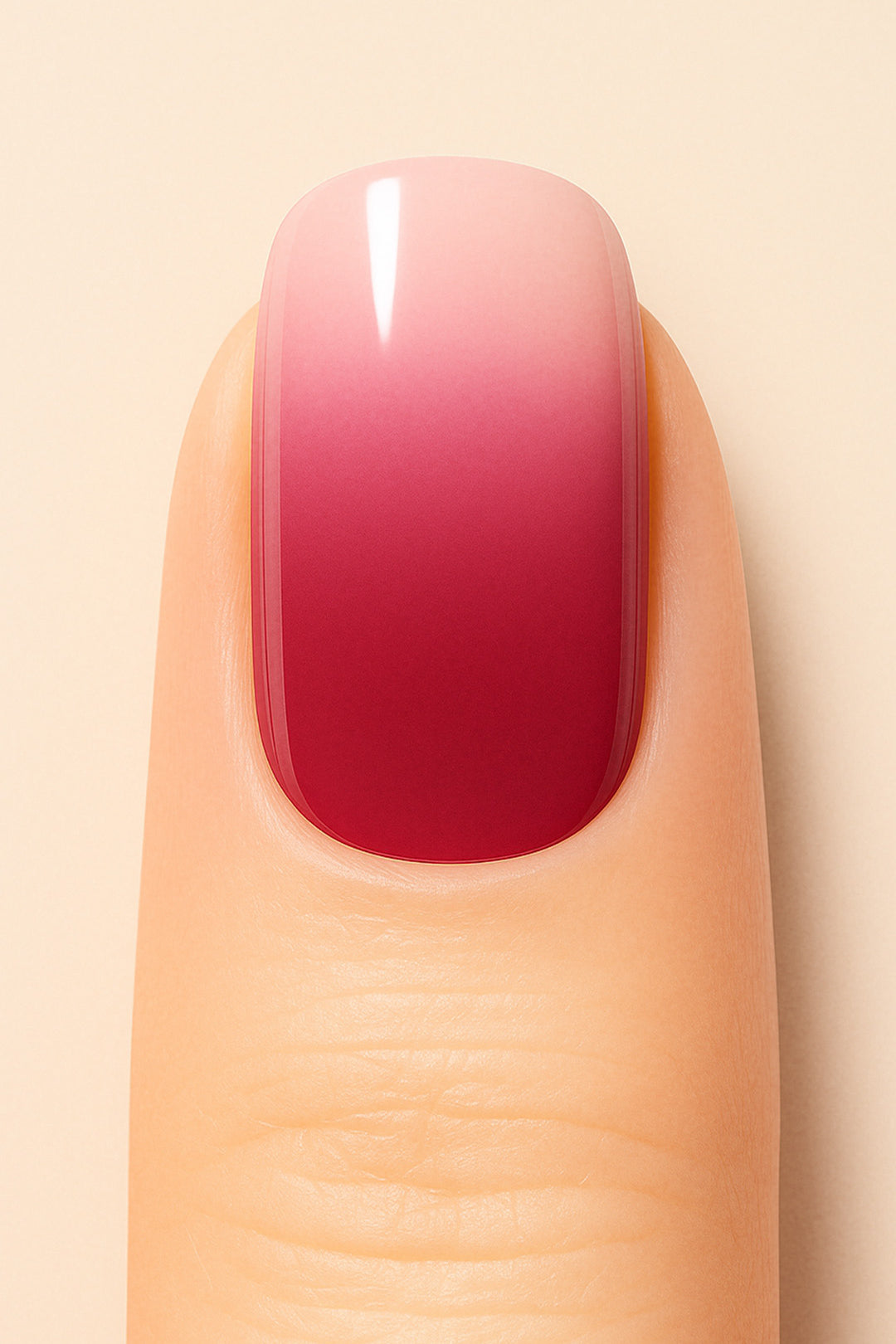 A close-up shot of a model’s finger wearing Blush Mist Ombre Nail Stickies, showcasing a smooth gradient that blends soft blush pink into a deep misty red, creating a chic and glossy ombre manicure finish – Muselot.