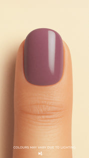 A close-up shot of a model’s thumb wearing Blushed Mauve nail stickies, showcasing the soft mauve shade with a smooth glossy solid finish, highlighting the elegance of minimal nail art in a refined and classy look – Muselot.