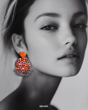 A model wearing Chakardi traditional art earrings, adorned with intricate patterns and bold designs that add a rich, cultural charm and sophisticated elegance to any look — Muselot.