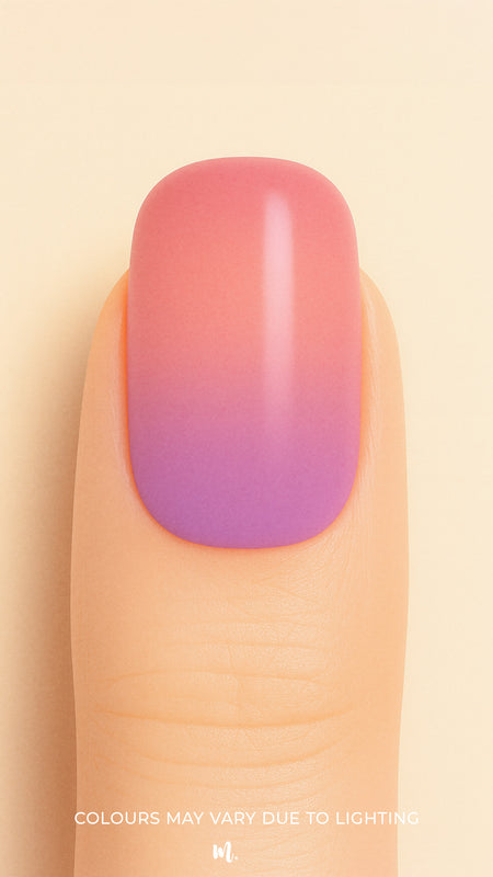 A close-up shot of a model’s finger wearing Coral Kiss Ombre Nail Stickies, showcasing a seamless transition from soft coral pink to a delicate lilac-purple tone, highlighting the smooth glossy finish and gradient charm of ombre nail art – Muselot.