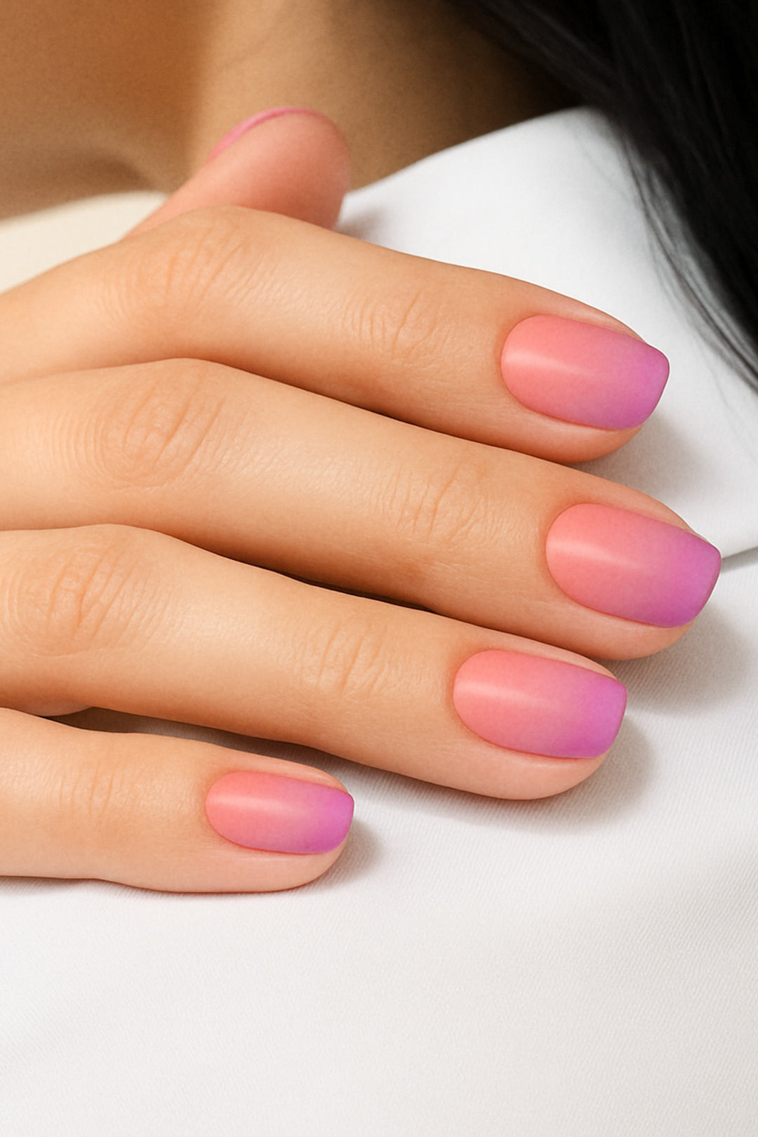 A model’s hand styled with Coral Kiss Ombre Nail Stickies, showcasing a smooth gradient blend from bright coral pink to soft lilac-purple, highlighting the glossy finish and effortless elegance of ombre nail art for a chic, salon-like look – Muselot.