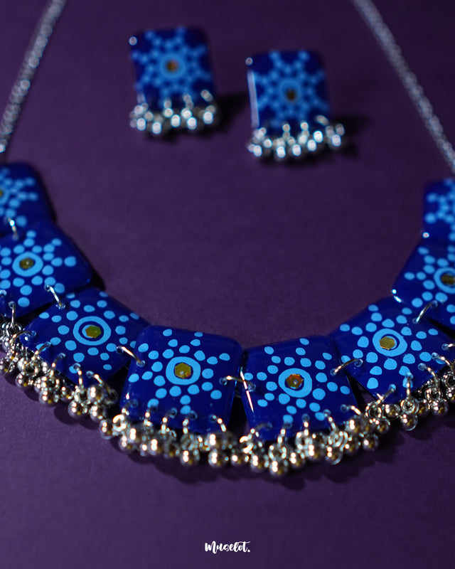 Falakzaar handmade blue necklace and earring set shown in a minimal close-up frame, highlighting the fine floral craftsmanship and showcasing the balanced fusion of color and design — Muselot.