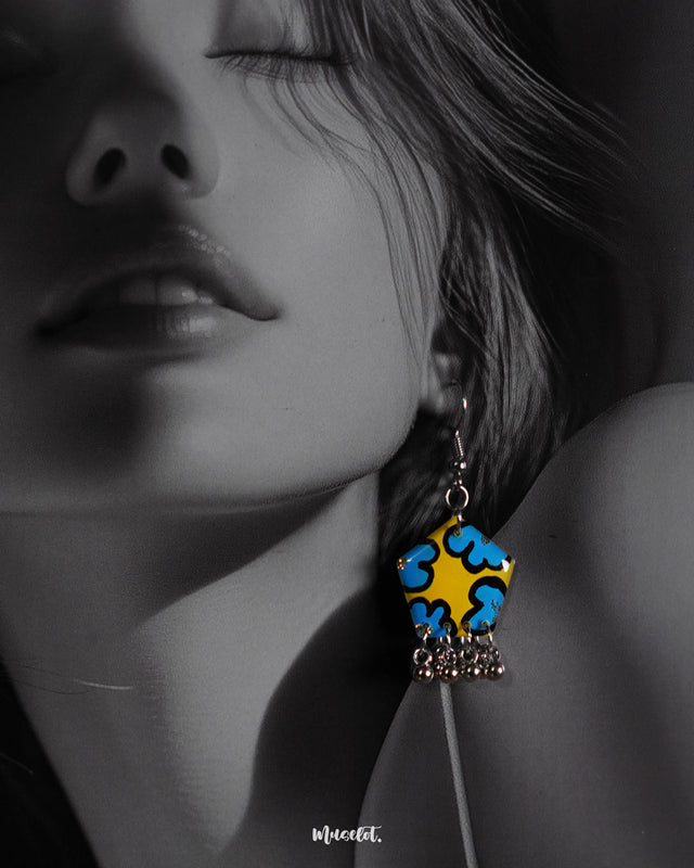 Close-up of a woman wearing the Gulaftab floral hook earrings, highlighting the striking blue and yellow floral pattern and silver bead details that enhance their artistic, handcrafted elegance — Muselot.