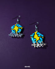 Gulaftab floral hook earrings displayed against a dark background, featuring a striking yellow base with bold blue flower patterns and silver bead hangings that enhance their handcrafted appeal — Muselot.