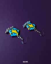 Gulaftab hook earrings captured from the front, showcasing the symmetrical floral patterns in rich blue against a vibrant yellow base, highlighting the handmade charm and graceful detailing — Muselot.