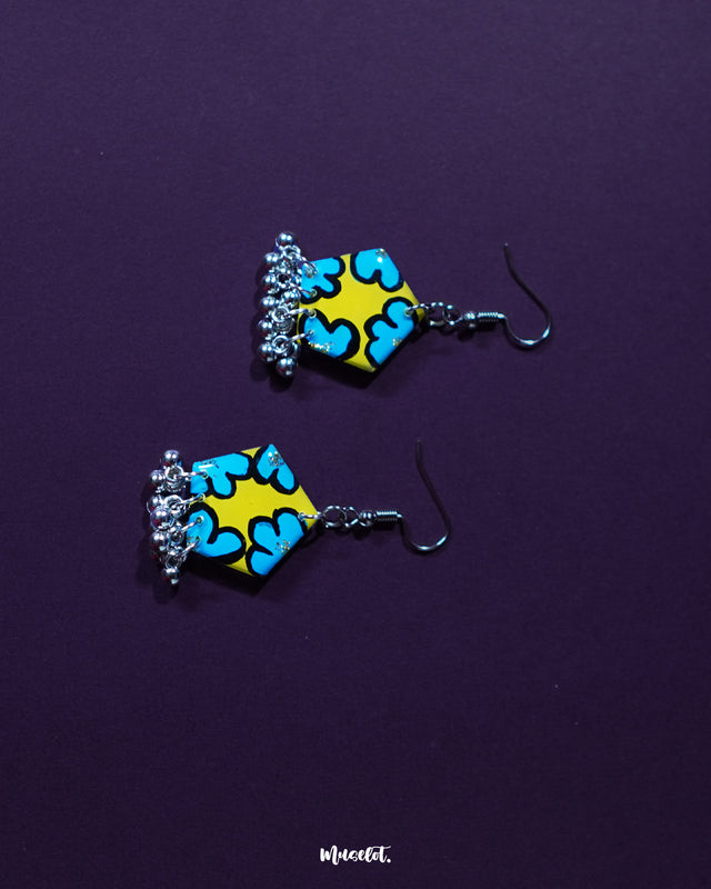 Gulaftab hook earrings displayed from a side angle, showcasing their delicate floral pattern in yellow and blue tones, highlighting handcrafted charm and artistic finesse — Muselot.
