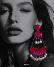 A close-up shot of a woman wearing the Gulfaam chandbali earrings showcases the intricate lilac leaf motifs on the glossy hot pink base, with soft pearl drops catching the light—blending charm and drama effortlessly — Muselot.