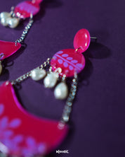 A close-up view of the Gulfaam pink pearl chandbali earrings captures the delicate detailing of the crescent frame, embellished with intricate accents and soft pink pearl drops that lend an air of elegance and sophistication — Muselot.