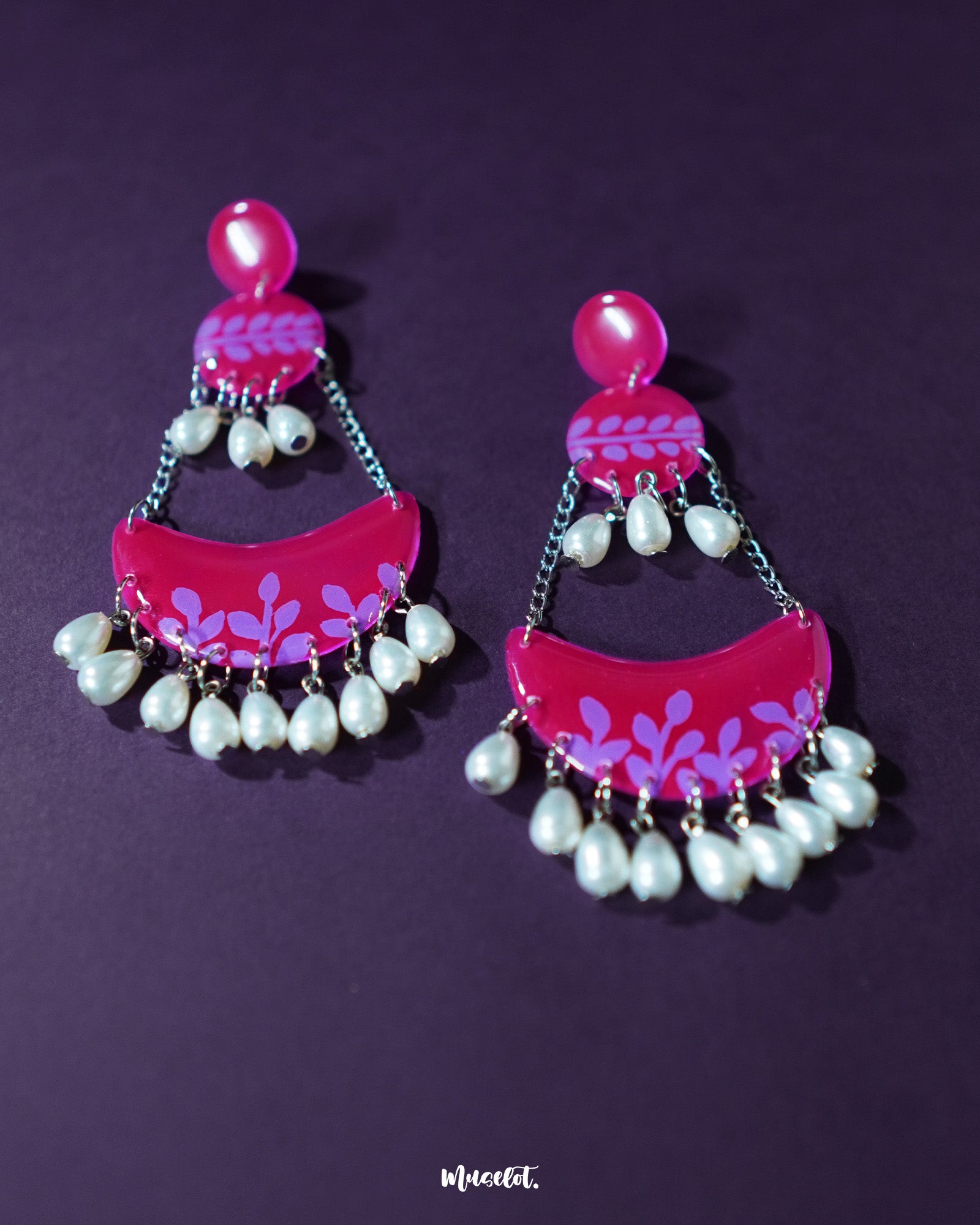 The Gulfaam pink pearl chandbali earrings are beautifully displayed against a soft background, highlighting their graceful crescent silhouette and the shimmer of dangling pink pearls that add a touch of regal charm — Muselot.