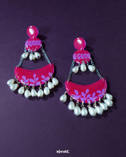 The Gulfaam pink pearl chandbali earrings are beautifully displayed against a soft background, highlighting their graceful crescent silhouette and the shimmer of dangling pink pearls that add a touch of regal charm — Muselot.