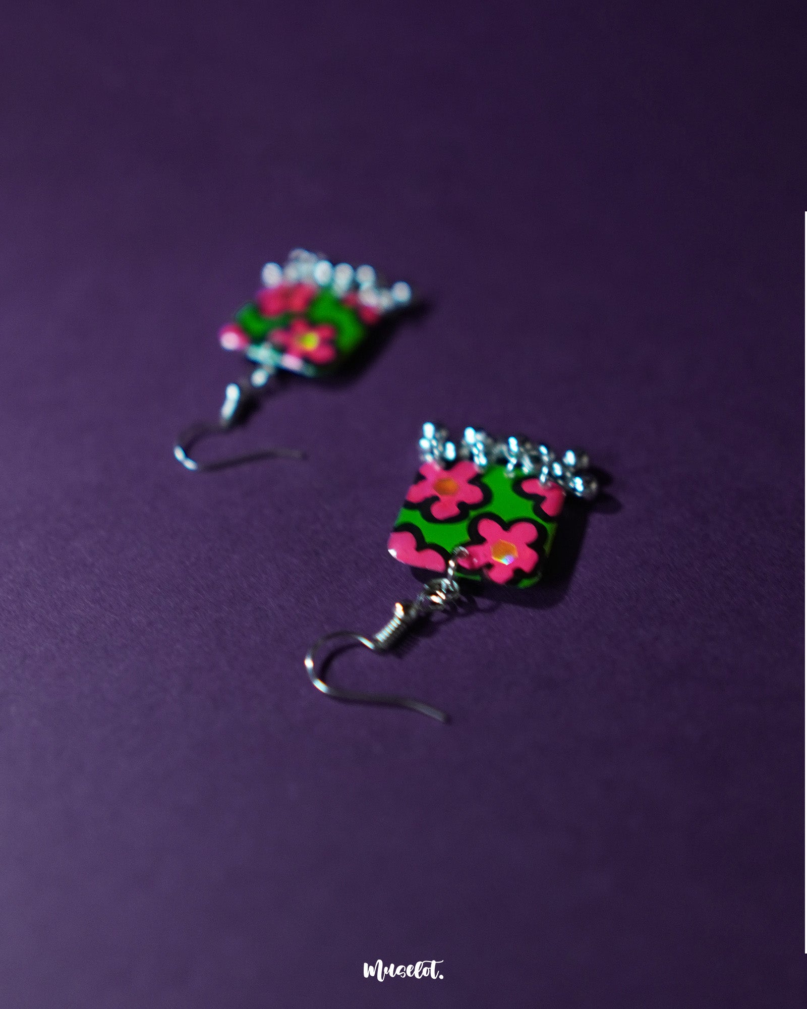 Gulnaar handmade floral hook earrings with rectangular charms displaying vivid pink and red flowers on a green background outlined in black, accented with delicate silver bead tassels, beautifully presented to showcase their colorful and intricate craftsmanship – Muselot.
