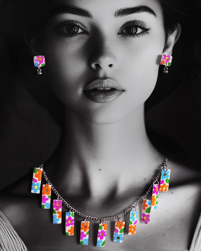 A model gracefully showcases the Gulraas handmade floral necklace set, where vibrant rectangular charms bloom in a rainbow of hand-painted florals—highlighting the whimsical spirit and statement appeal of this artisanal creation — Muselot.