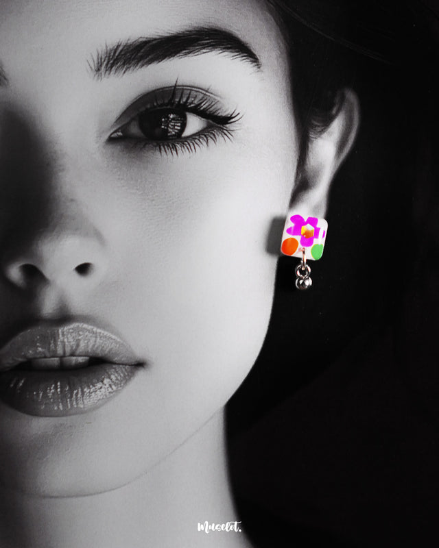 A model wears the Gulraas handmade floral stud earrings, highlighting the delicate pop of color and playful charm these tiny hand-painted blooms bring—perfect for adding a joyful accent to everyday looks — Muselot.