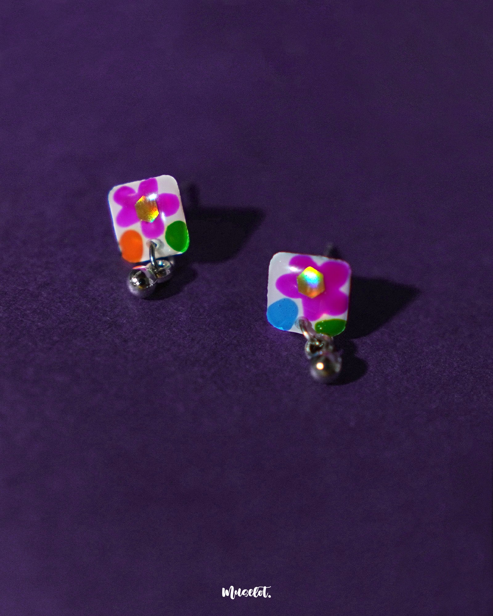 A detailed look at the floral stud earrings from the Gulraas necklace set reveals tiny hand-painted flowers in vibrant hues of orange, pink, and yellow, paired with delicate dangling beads—showcasing the intricate craftsmanship and playful detailing of this handmade set — Muselot.