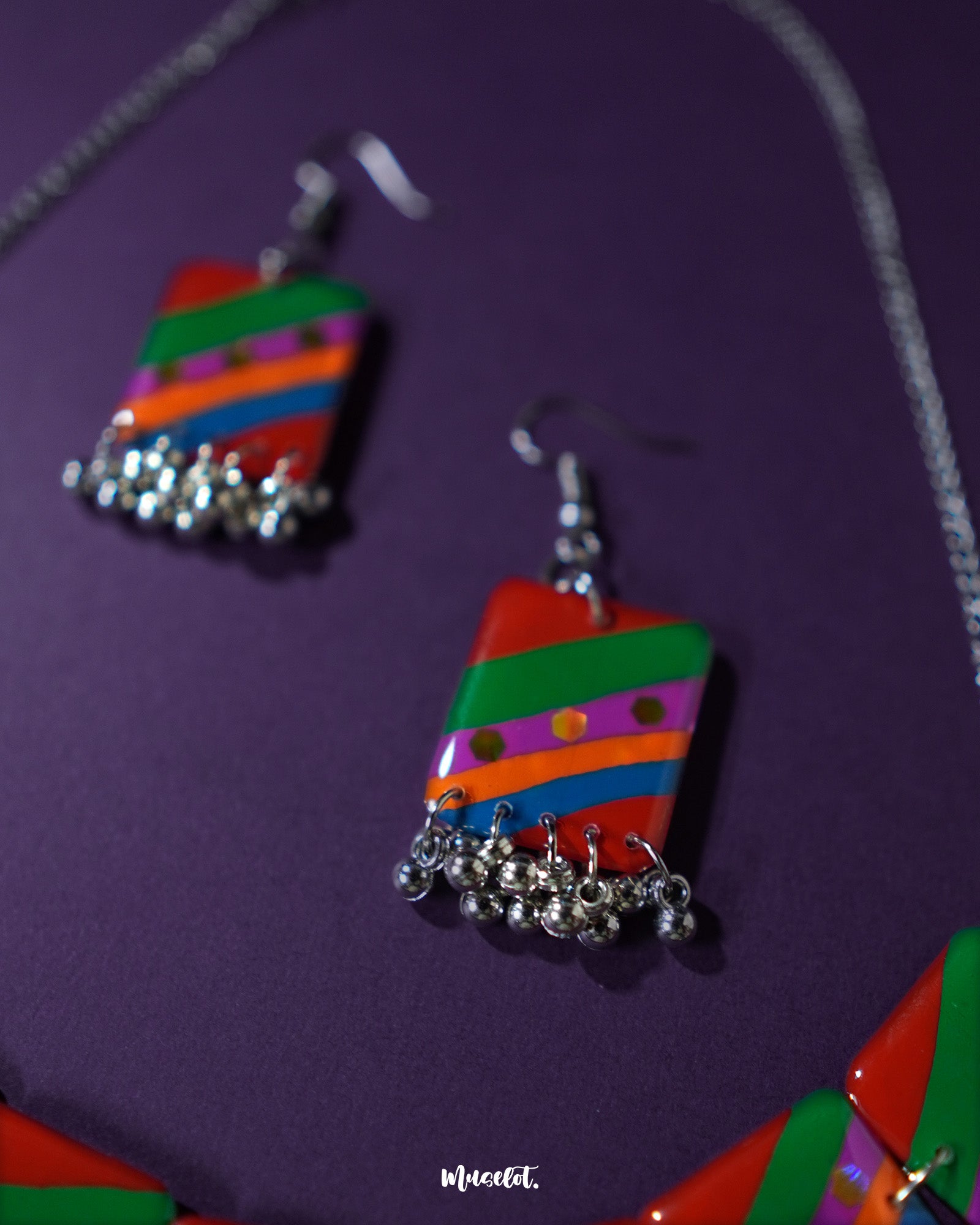 Gulrang multicolor resin earrings featuring bold red, green, blue, and purple striped rectangular charms with dotted accents and delicate silver bead tassels, beautifully showcased to highlight their vibrant and artistic design – Muselot.