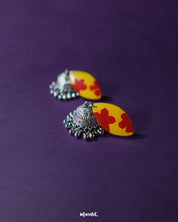 Front display of Gulrukh floral jhumkas, featuring yellow-red hand-painted tops with oxidized silver jhumka drops on a simple backdrop – Muselot.