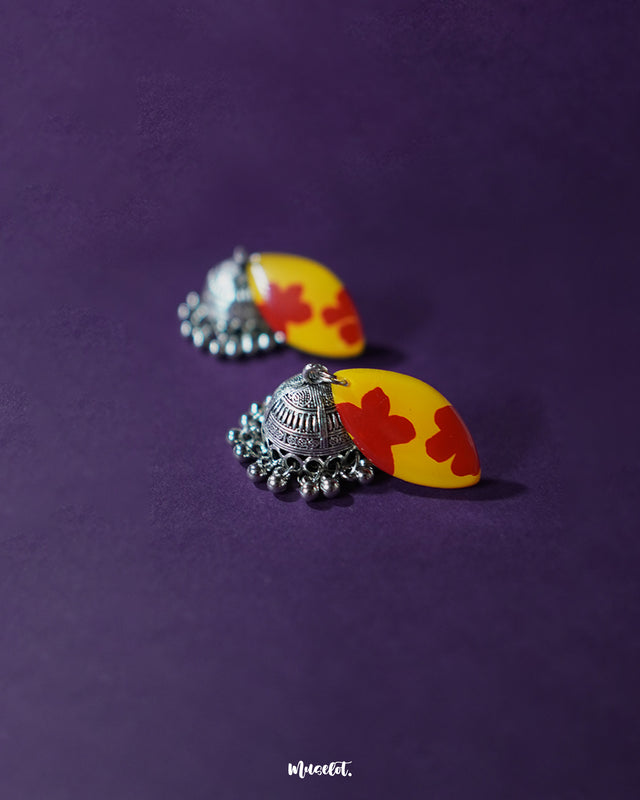 Front display of Gulrukh floral jhumkas, featuring yellow-red hand-painted tops with oxidized silver jhumka drops on a simple backdrop – Muselot.