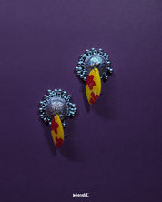 Side angle of Gulrukh floral jhumkas, highlighting the painted floral top and oxidized silver dome with engraved detailing on a plain background – Muselot.