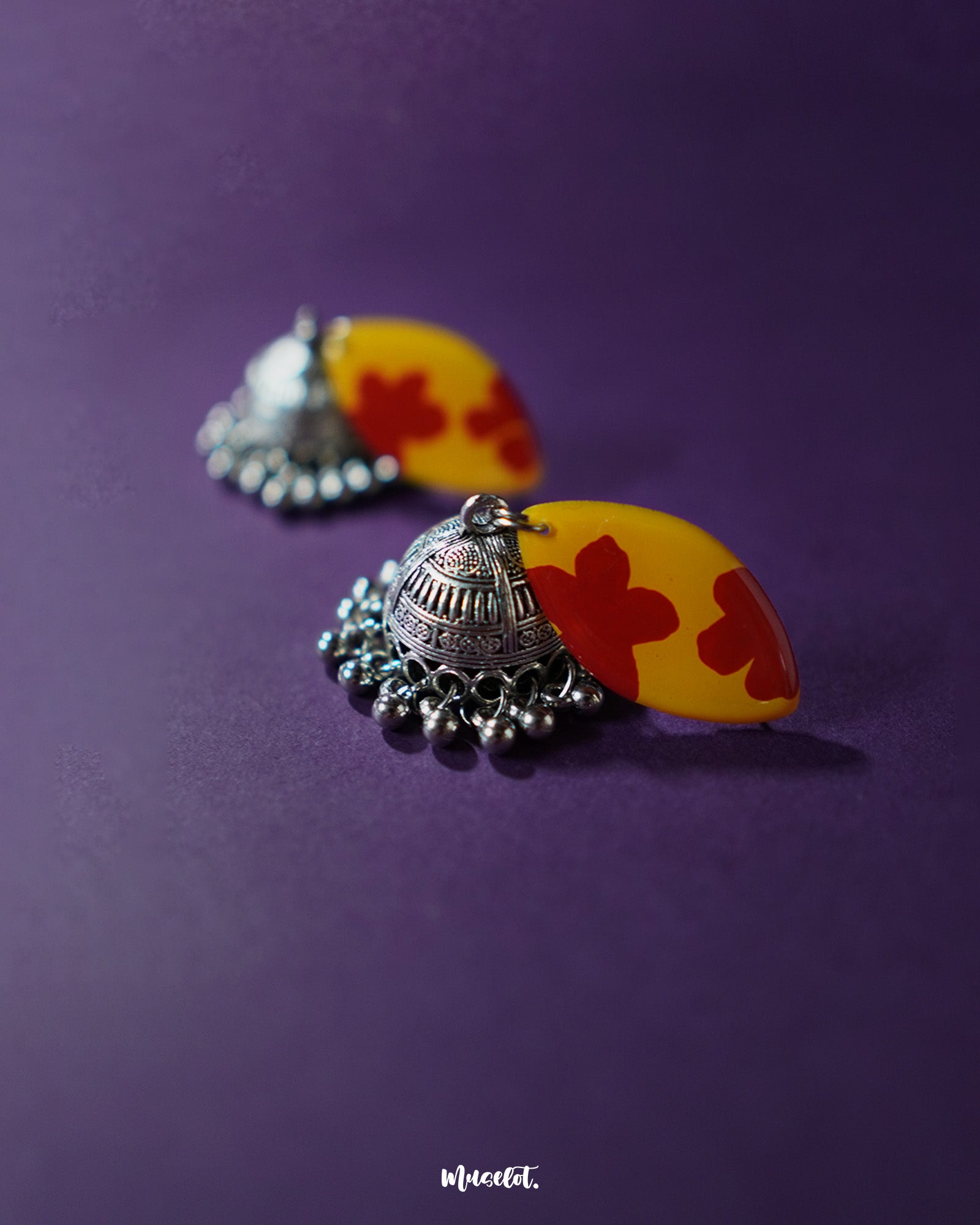 Pair of Gulrukh floral jhumkas laid flat, showcasing the hand-painted floral tops and engraved oxidized silver domes on a neutral background – Muselot.