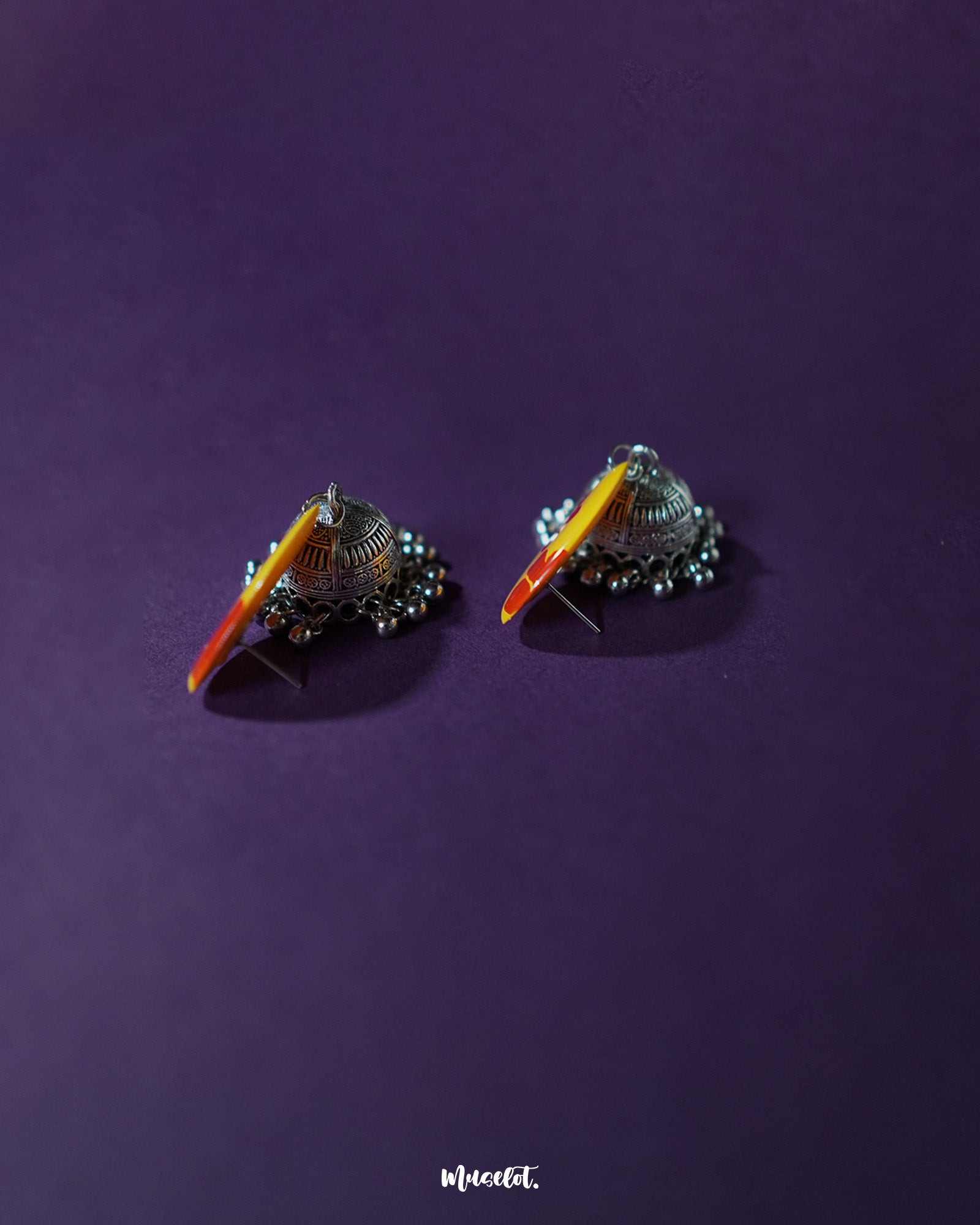 Angled display of Gulrukh floral jhumkas, emphasizing the vibrant floral top and antique-style oxidized silver dome with etched details – Muselot.