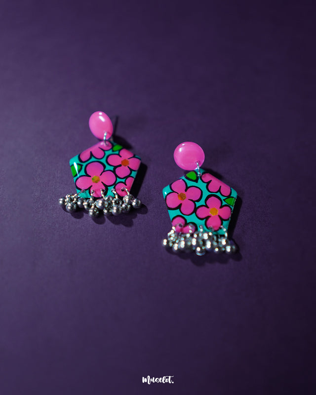 Gulshafa pink floral drop earrings, beautifully set against a soft purple background, with vibrant pink hues and intricate floral details that highlight their playful yet elegant boho charm — Muselot.