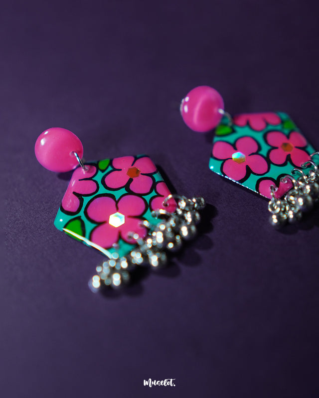 Gulshafa pink floral drop earrings, displayed against a rich purple backdrop, with soft pink floral accents and detailed craftsmanship that bring out their vibrant yet graceful boho appeal — Muselot.