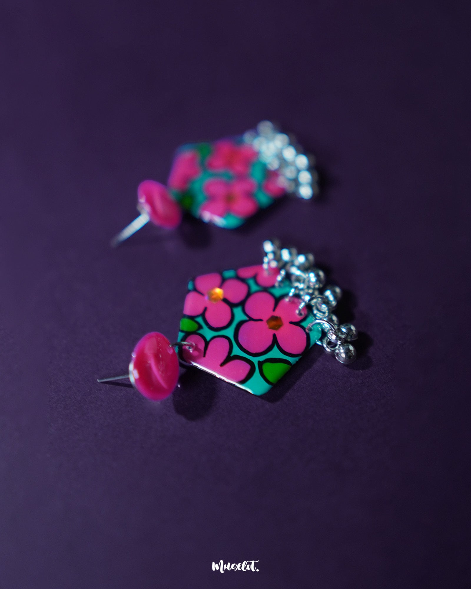 Gulshafa pink floral drop earrings, framed by a deep purple background, featuring delicate pink petals and intricate detailing that highlight their charming boho elegance — Muselot.