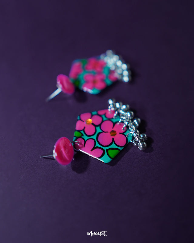 Gulshafa pink floral drop earrings, framed by a deep purple background, featuring delicate pink petals and intricate detailing that highlight their charming boho elegance — Muselot.