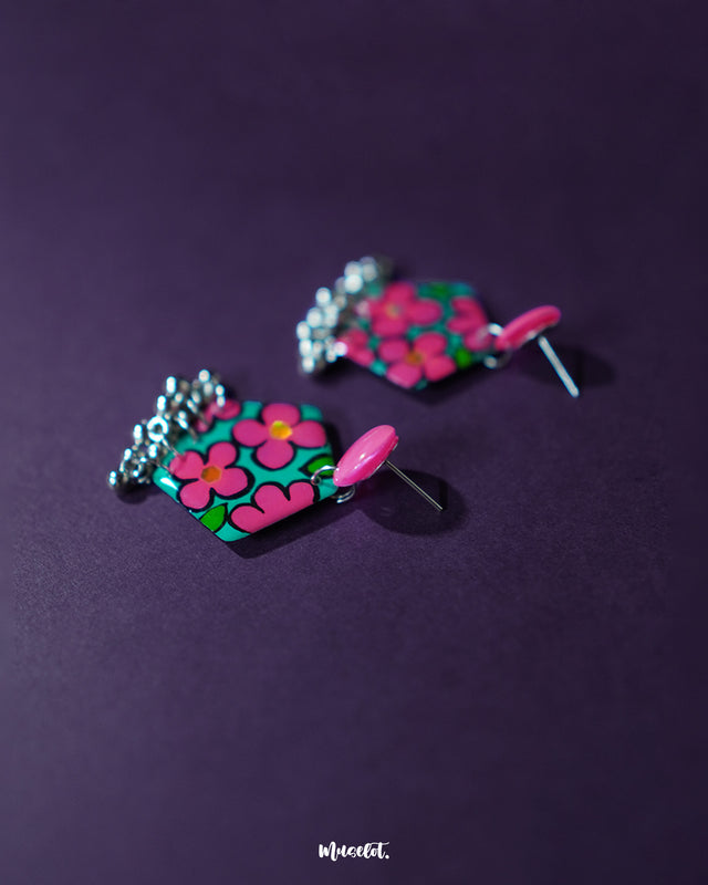 Gulshafa pink floral drop earrings, set against a dark purple background, with soft pink hues and intricate floral patterns that bring out their elegant yet playful boho flair — Muselot.