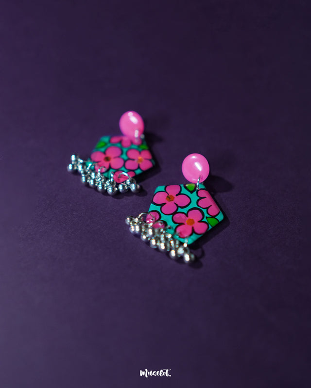Gulshafa pink floral drop earrings, showcased against a deep purple backdrop, with delicate pink floral accents and intricate detailing that enhance their bohemian charm and elegance — Muselot.