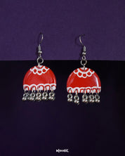 Gulzaib red hook earrings featuring delicate white flowers, beautifully highlighted against a contrasting backdrop, showcasing a fusion of vibrant red and soft floral details — Muselot.