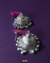 Zoomed-in shot of the bottom part of the Gulzarish floral jhumkas, highlighting the intricately carved oxidized silver dome-shaped drops with delicate hanging beads, showcasing the fine detailing and traditional craftsmanship – Muselot.