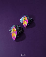 Top view of the upper part of the Gulzarish floral jhumkas, showcasing the marquise-shaped purple tops adorned with orange and yellow leaf motifs accented by green dots, highlighting the vibrant colors and intricate hand-painted detailing – Muselot.