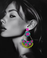 A woman wearing handmade chandbali earrings featuring intricate floral motifs and vibrant beads, showcasing the detailed craftsmanship and festive elegance of this colorful accessory — Muselot.