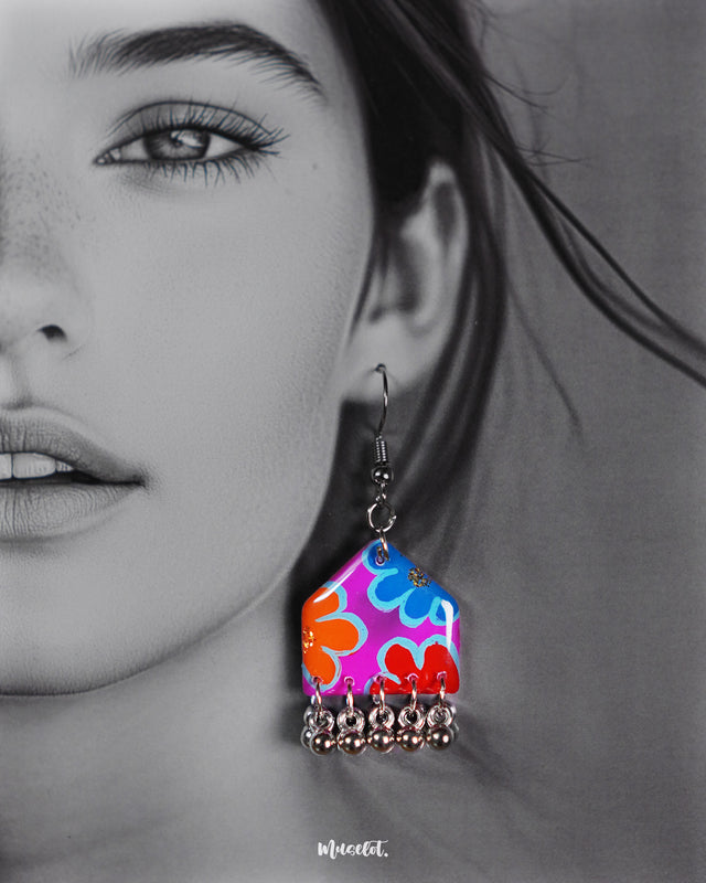 Close-up of model wearing hand-painted earrings, featuring vibrant multicolour floral design with silver ghungroo drops, styled to highlight the bold artistic detailing – Muselot.