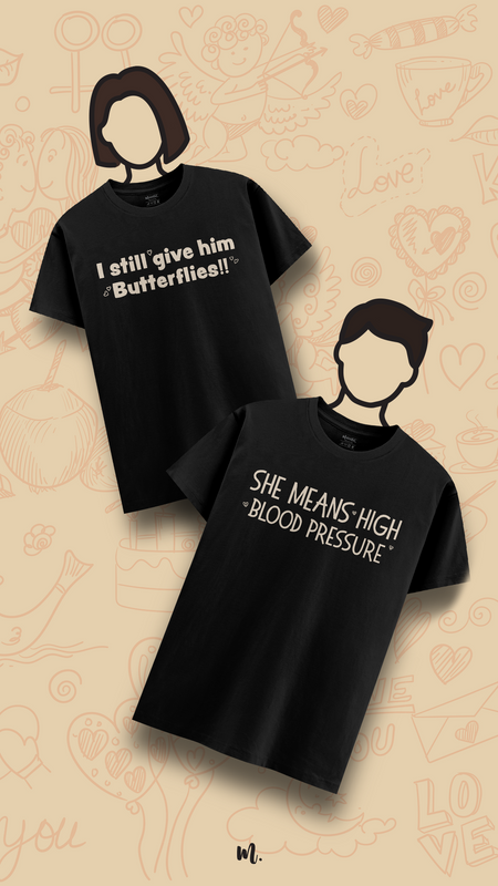 Black couple graphic t-shirts showcasing “I still give him Butterflies!!” and “She Means High Blood Pressure,” highlighting a humorous contrast between romance and dramatic energy, styled on illustrated characters against a doodle-themed romantic beige background – Muselot