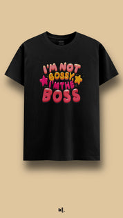 Black graphic t-shirt showcasing the “I’m Not Bossy I’m The Boss” statement, highlighting a strong, self-assured personality with bright, eye-catching design elements against a clean beige background – Muselot