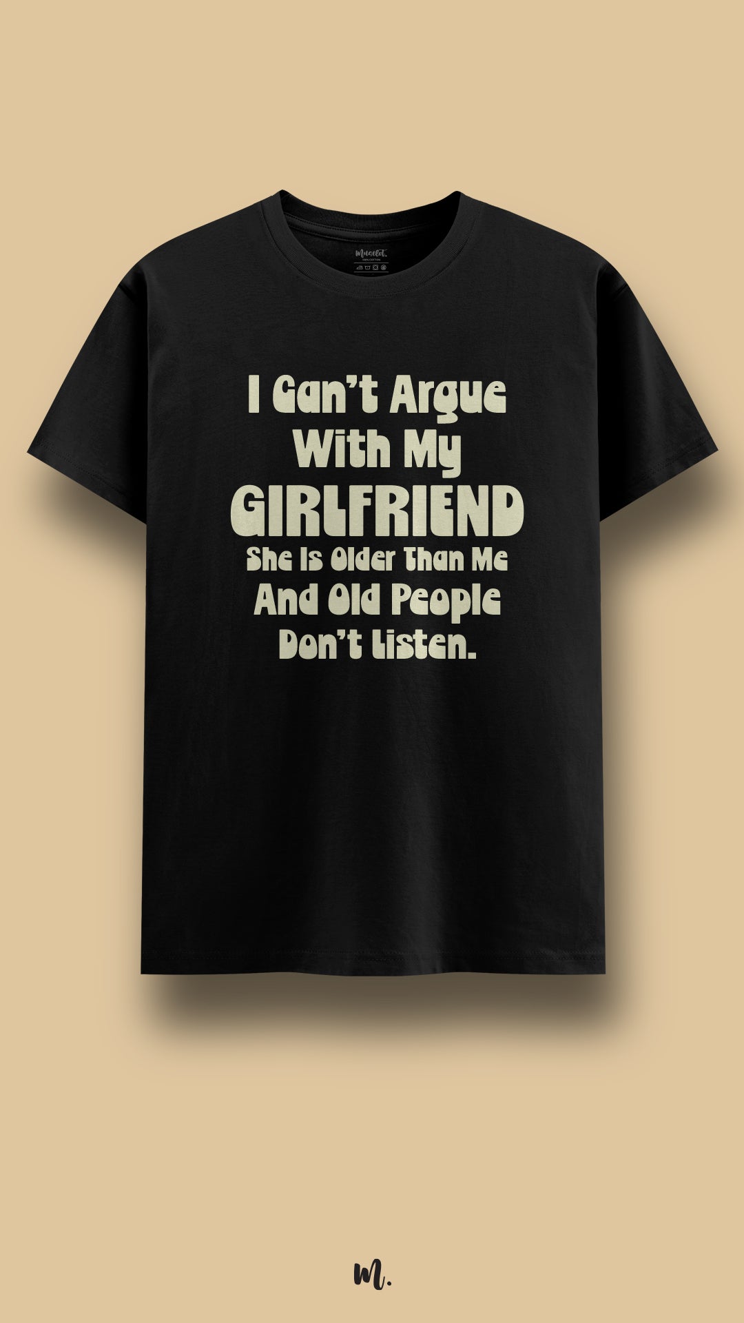 Black graphic t-shirt showcasing the statement “I Can’t Argue With My Girlfriend She Is Older Than Me And Old People Don’t Listen.” in soft high-contrast rounded lettering, highlighting witty couple humor in a clean beige studio presentation – Muselot