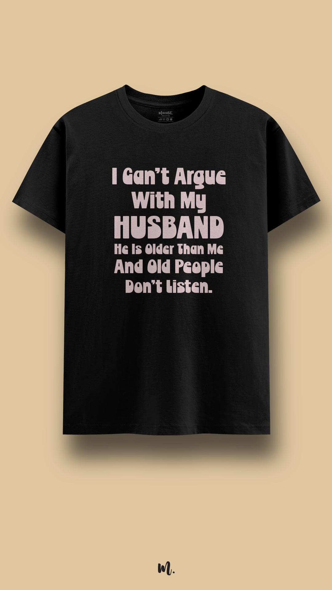 Black graphic t-shirt showcasing the statement “I Can’t Argue With My Husband He Is Older Than Me And Old People Don’t Listen.” in soft high-contrast lettering, highlighting witty relationship humor in a clean beige studio presentation – Muselot