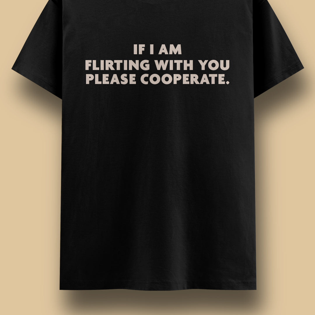 Black graphic t-shirt showcasing the “If I Am Flirting With You Please Cooperate.” statement, highlighting a playful, confident, and cheeky flirting attitude against a clean beige background – Muselot